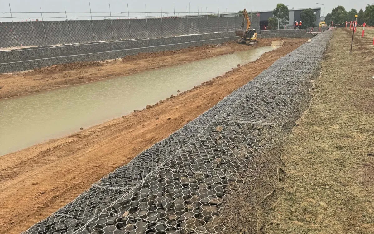 Rock-filled gabion basket retaining wall