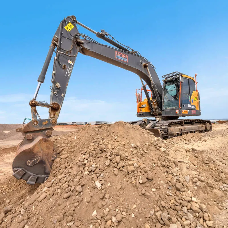 UCBC excavator and operator placing precast retaining wall units