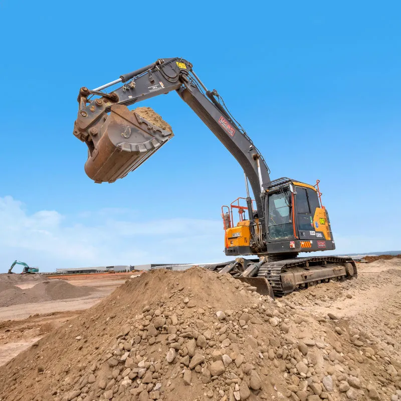 UCBC excavator and operator placing precast retaining wall units