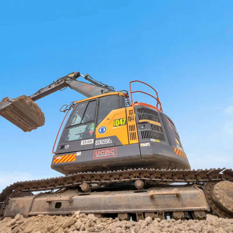 UCBC excavator and operator placing precast retaining wall units