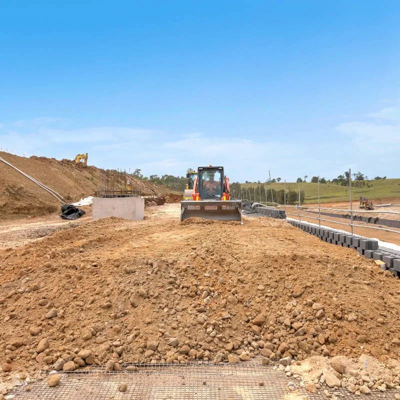 UCBC excavator and operator placing precast retaining wall units
