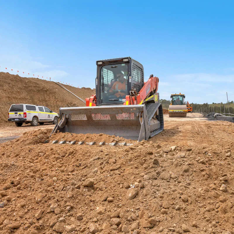 UCBC excavator and operator placing precast retaining wall units