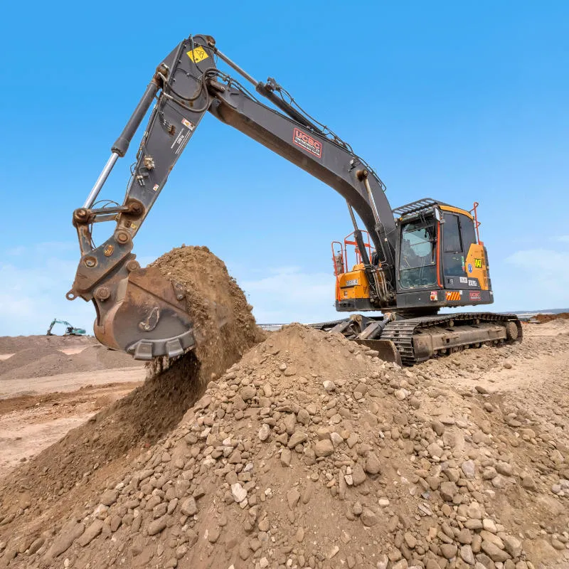 UCBC excavator and operator placing precast retaining wall units