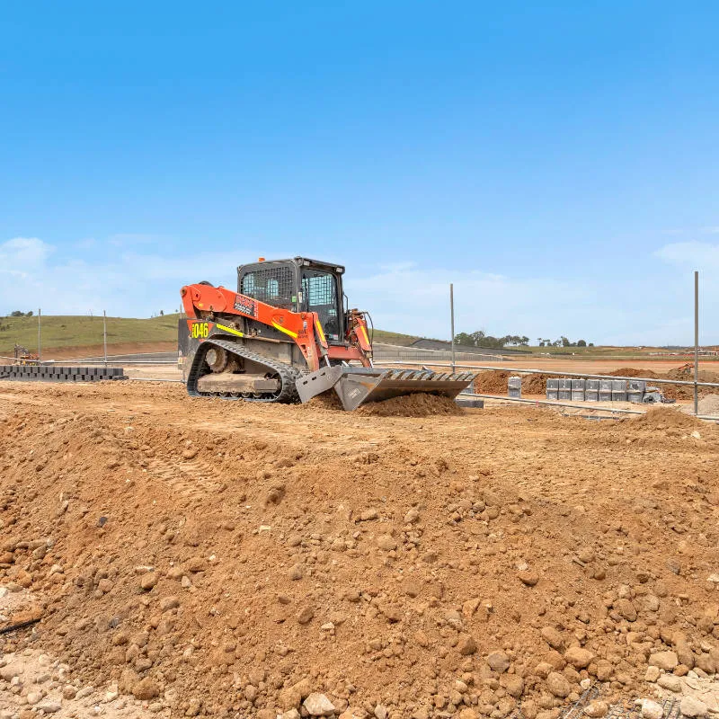 UCBC excavator and operator placing precast retaining wall units