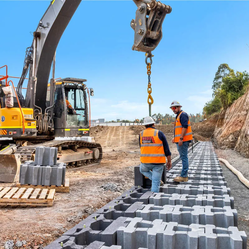 UCBC excavator and operator placing precast retaining wall units