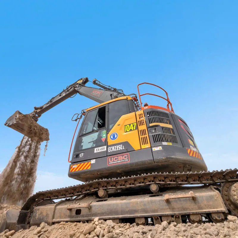 UCBC excavator and operator placing precast retaining wall units