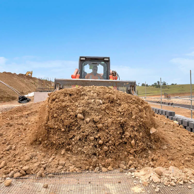 UCBC excavator and operator placing precast retaining wall units
